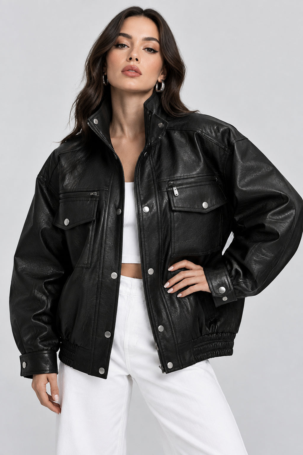 Woman wearing a black leather jacket on a plain background